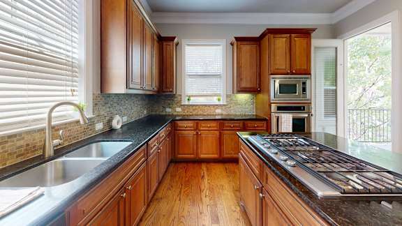 A kitchen with wooden cabinets and a black countertop.