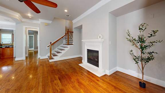A living room with a fireplace and a tree.