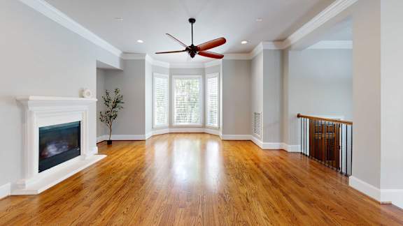 A room with a fireplace and a ceiling fan.