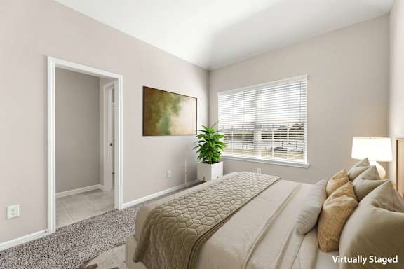 A bedroom with a bed, a plant, and a painting on the wall.