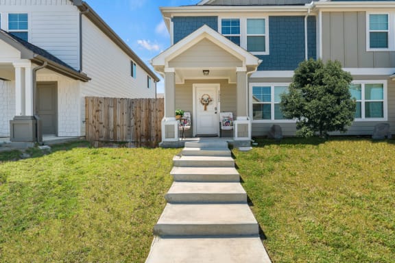 a sidewalk in front of a house with a porch