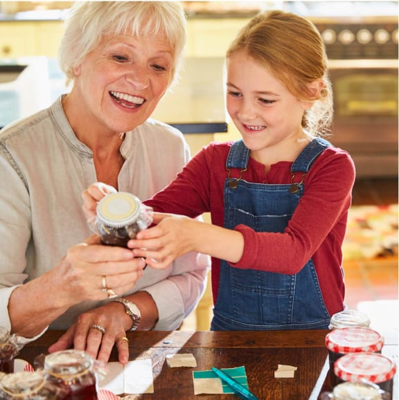 a woman and a young girl making cupcakes