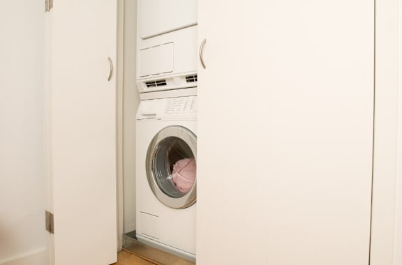 A white washing machine is in a small room.