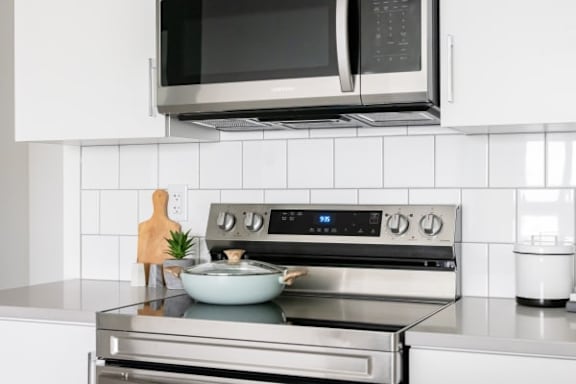 A modern kitchen with a stove top oven and microwave above it.