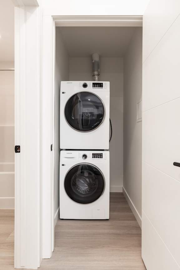 A white washing machine and dryer in a small laundry room.
