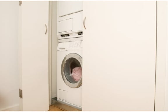 A white washing machine is in a small room.