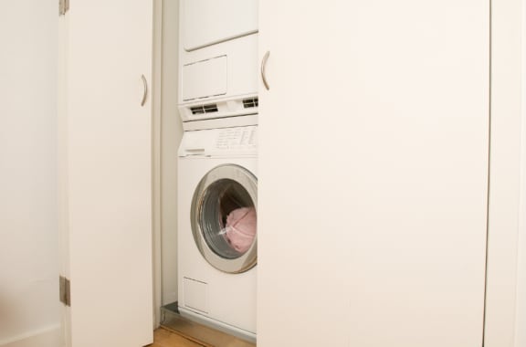 a white washer and dryer in a white closet