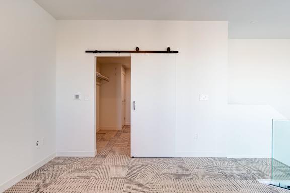 a sliding door in a room with white walls and a tiled floor
