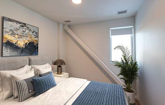 a bedroom with a bed and a potted plant and a window