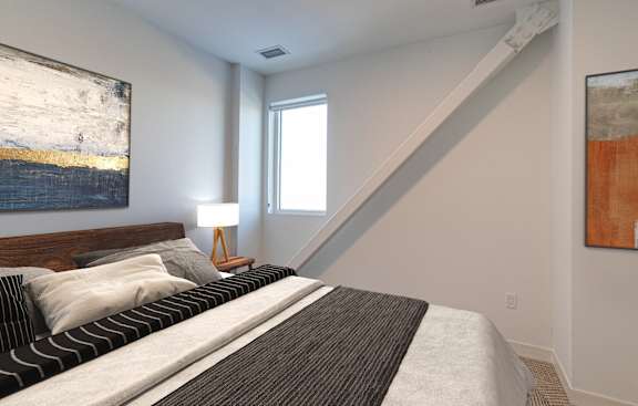 a bedroom with a bed and two paintings on the wall