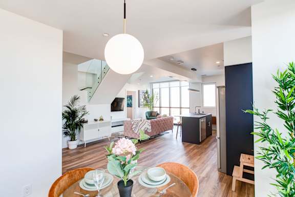 a living room and dining room with a table and chairs