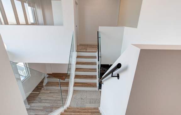 a view of the staircase of a house with a glass railing