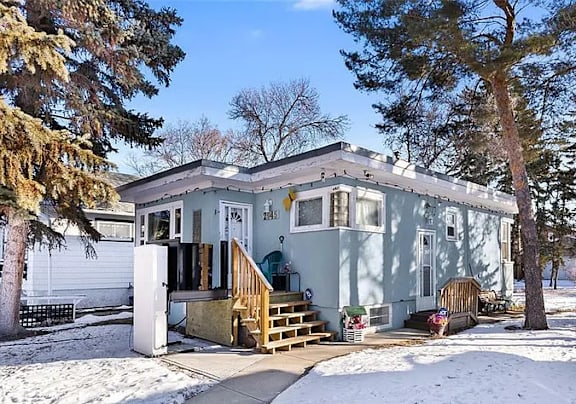 A house with a white door and a porch with a wooden railing.