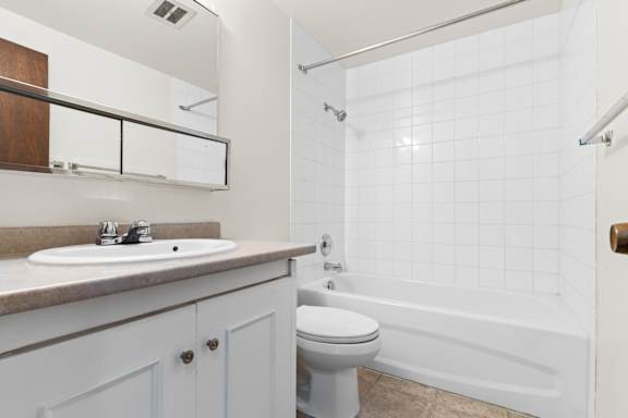A white bathroom with a sink, toilet, and bathtub.