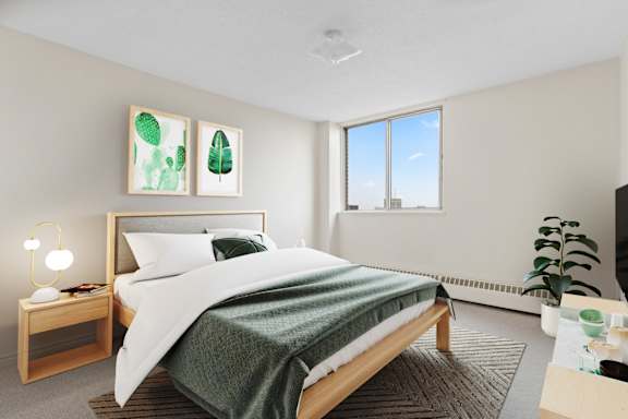 A bedroom with a large bed and a green blanket.