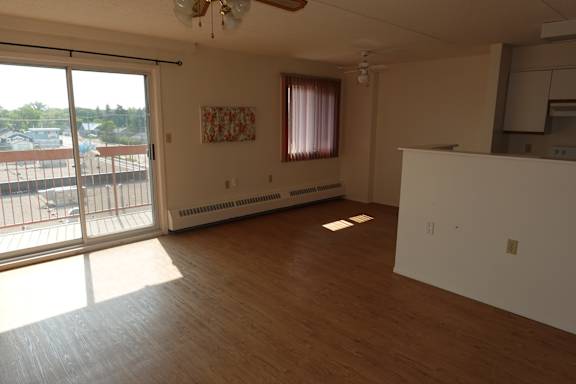 A room with a sliding glass door and a ceiling fan.