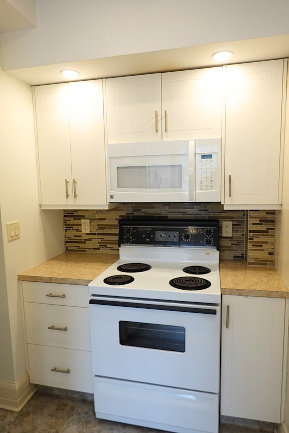 A modern kitchen with a large island and stainless steel appliances.