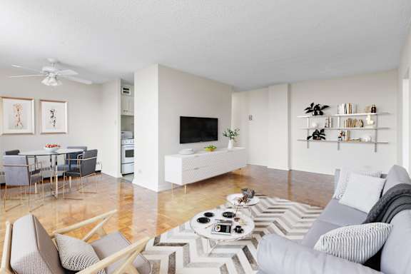 A modern living room with a grey sofa and a white coffee table.