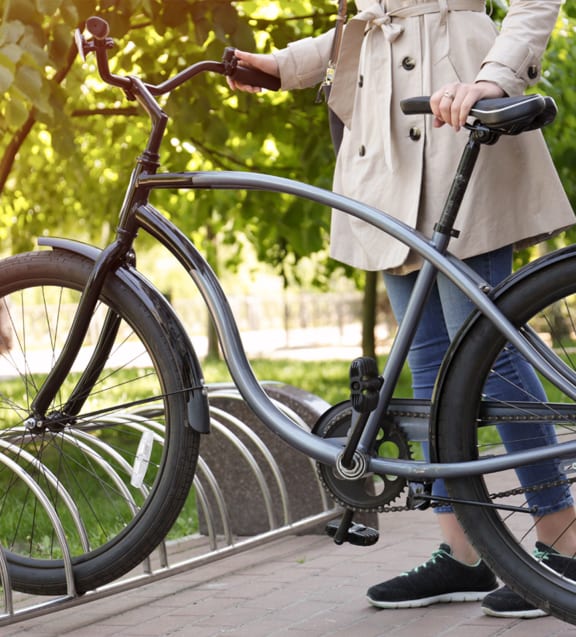 a woman is standing next to a bicycle in a park