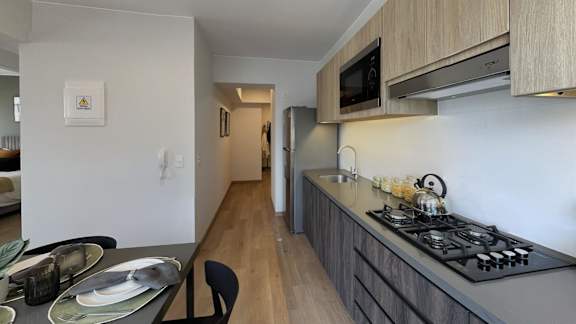 A modern kitchen with a dining table set for two.