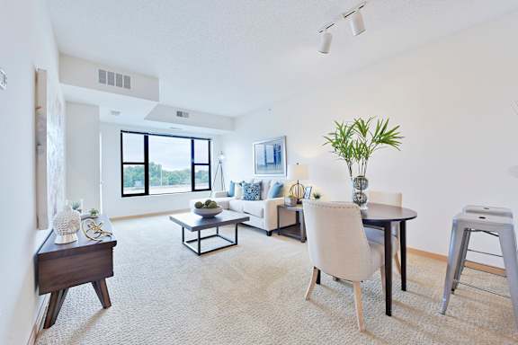 A living room with a white couch, a black coffee table, and a white chair.