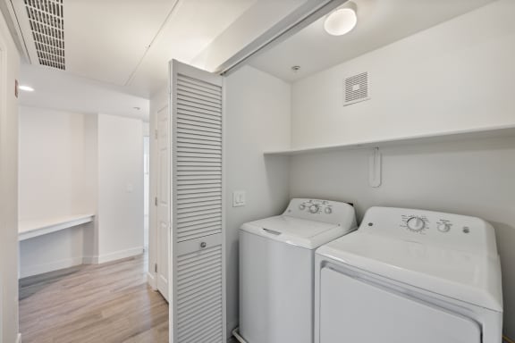 a white laundry room with two washes and a dryer in it