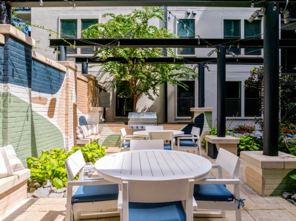 a patio with tables and chairs in front of a building