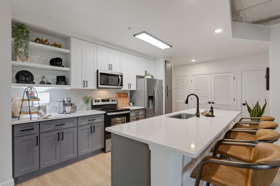 a kitchen with a white counter top and gray cabinets