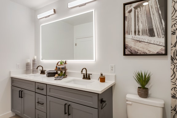 a bathroom with a large mirror and a sink and a toilet