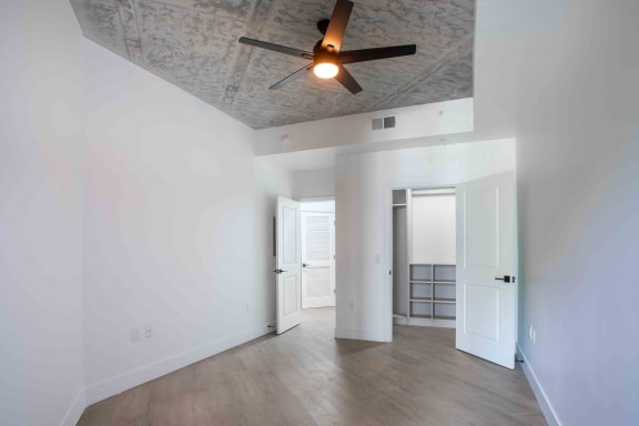 a living room with white walls and a ceiling fan