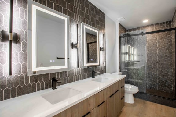 a bathroom with two sinks and a shower and a toilet