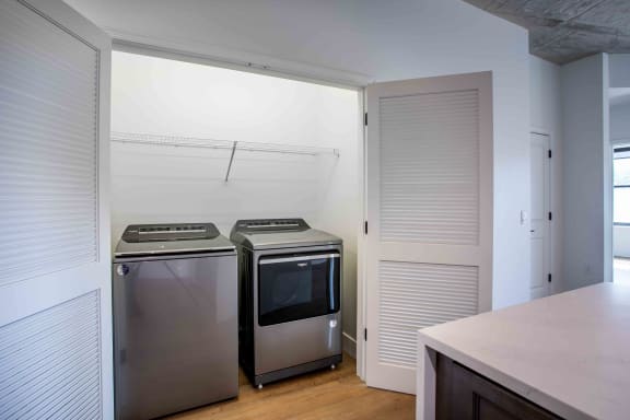 a kitchen with stainless steel appliances and a white closet