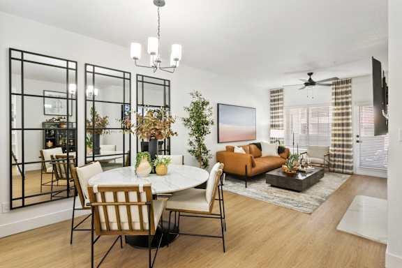 a living room and dining room with a table and chairs