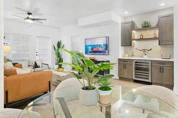 A modern living room with a television, a couch, and a glass table.