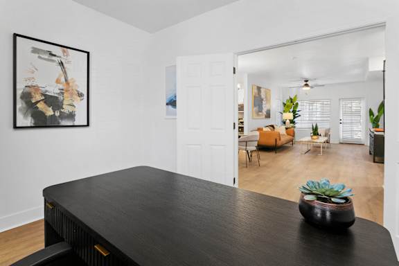 A black piano in a room with a painting on the wall.