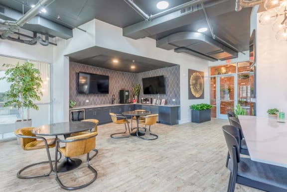 a lobby with tables and chairs and a tv