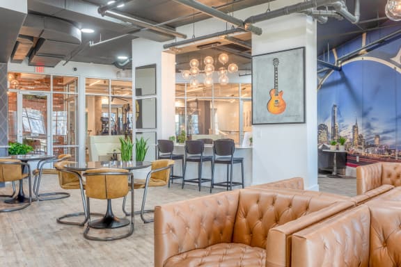 a lobby with couches chairs and tables and a guitar on the wall