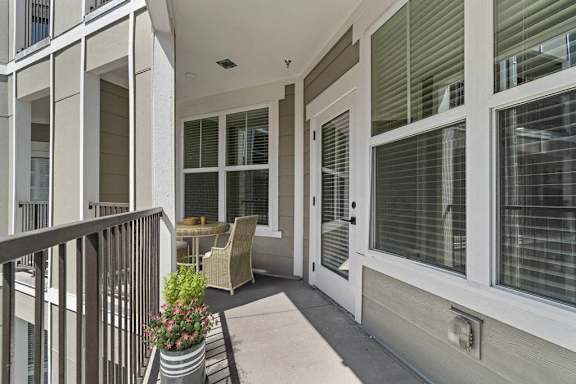 A balcony with a table and chairs.