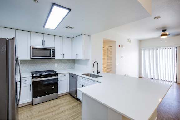 A kitchen with white countertops and stainless steel appliances.