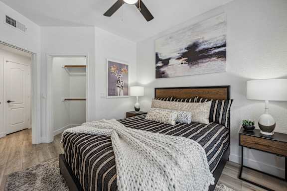 A bedroom with a large bed and a ceiling fan.