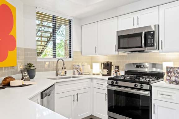 A kitchen with white cabinets and a black stove top oven.