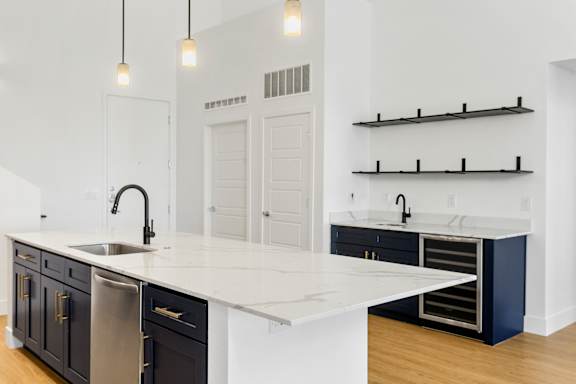 A kitchen with a white countertop and black cabinets.