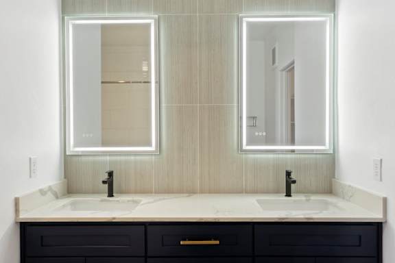 A bathroom with two sinks and two mirrors.