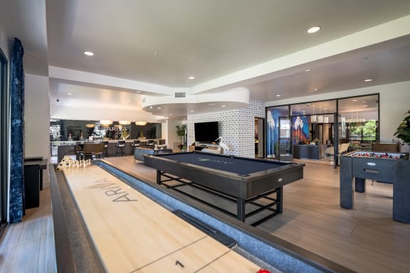 a game room with a pool table and shuffleboard
