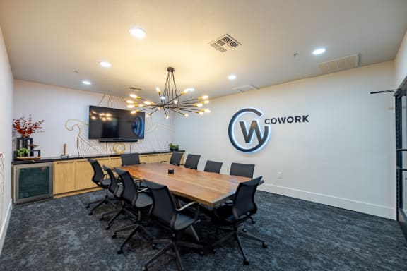 a conference room with a wooden table and chairs and a tv on the wall