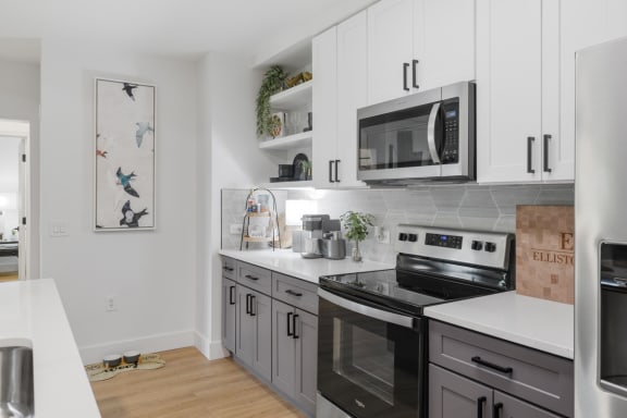 a kitchen with stainless steel appliances and white cabinets