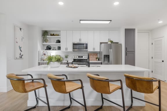 a kitchen with a large island and three chairs