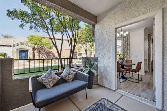 A patio with a couch and a table with chairs is shown.