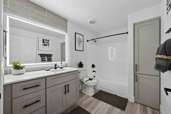 A bathroom with a toilet, sink, and mirror.
