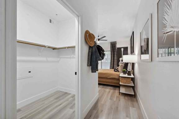 A hallway with a coat rack and a bench.